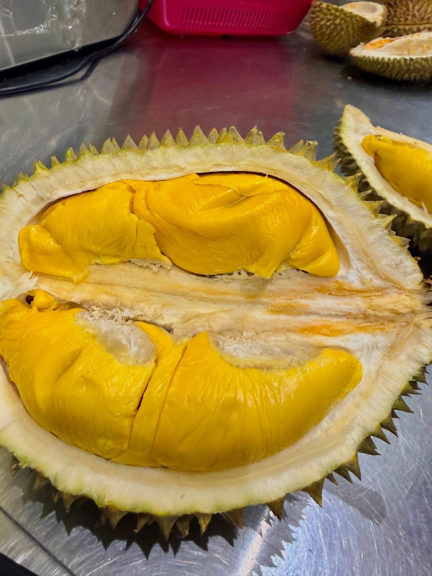Close-up of a freshly opened durian showing its rich golden-yellow flesh