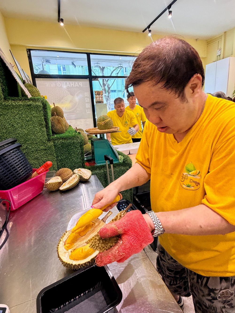A facilitator opening a fresh durian by hand during a durian demonstration