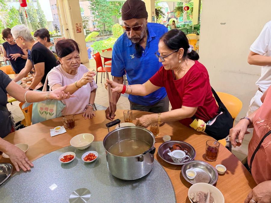 Seniors helping each other at the BKT pot at Outram Ya Hua