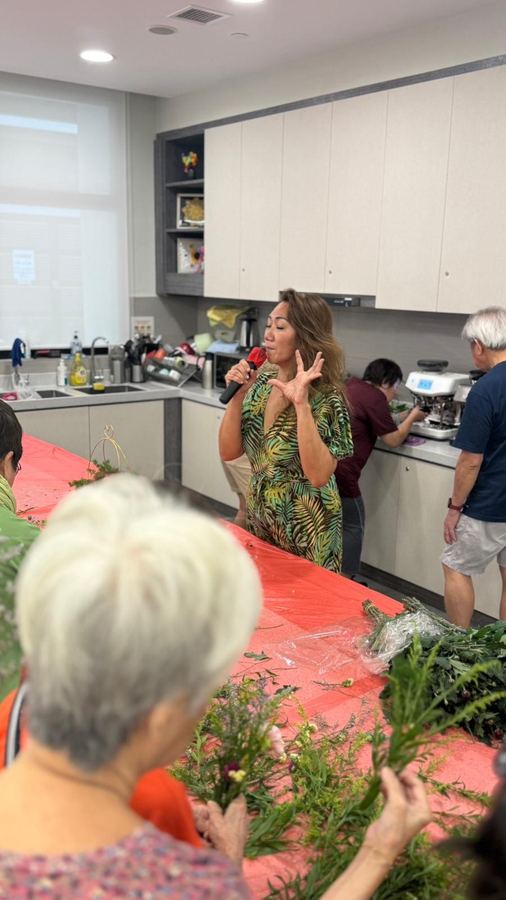 Instructor demonstrating flower arrangement technique to a group of seniors