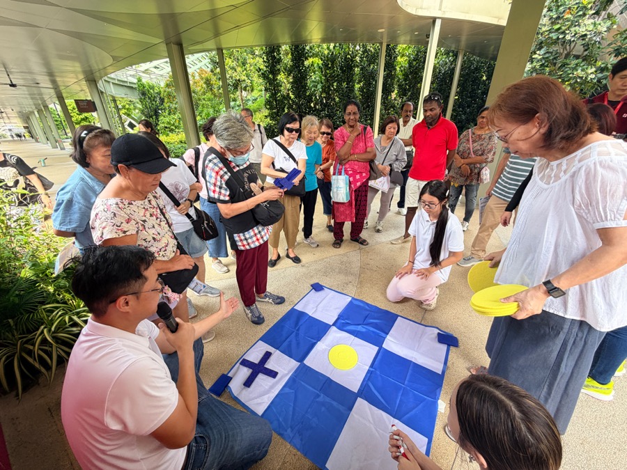 An Edufarm facilitator leading a seniors group through a team challenge on Sentosa