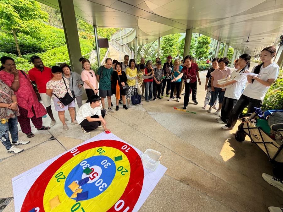 A seniors group gathered around a giant target game during a Sentosa team-challenge session