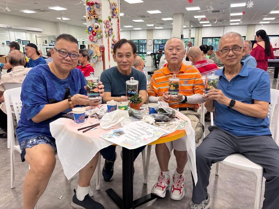 Seniors enjoying terrarium workshop — building miniature glass gardens